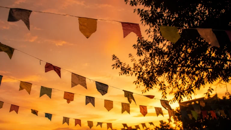 Bandeirinhas de papel penduradas em quintal ao entardecer — sonhar com festa
