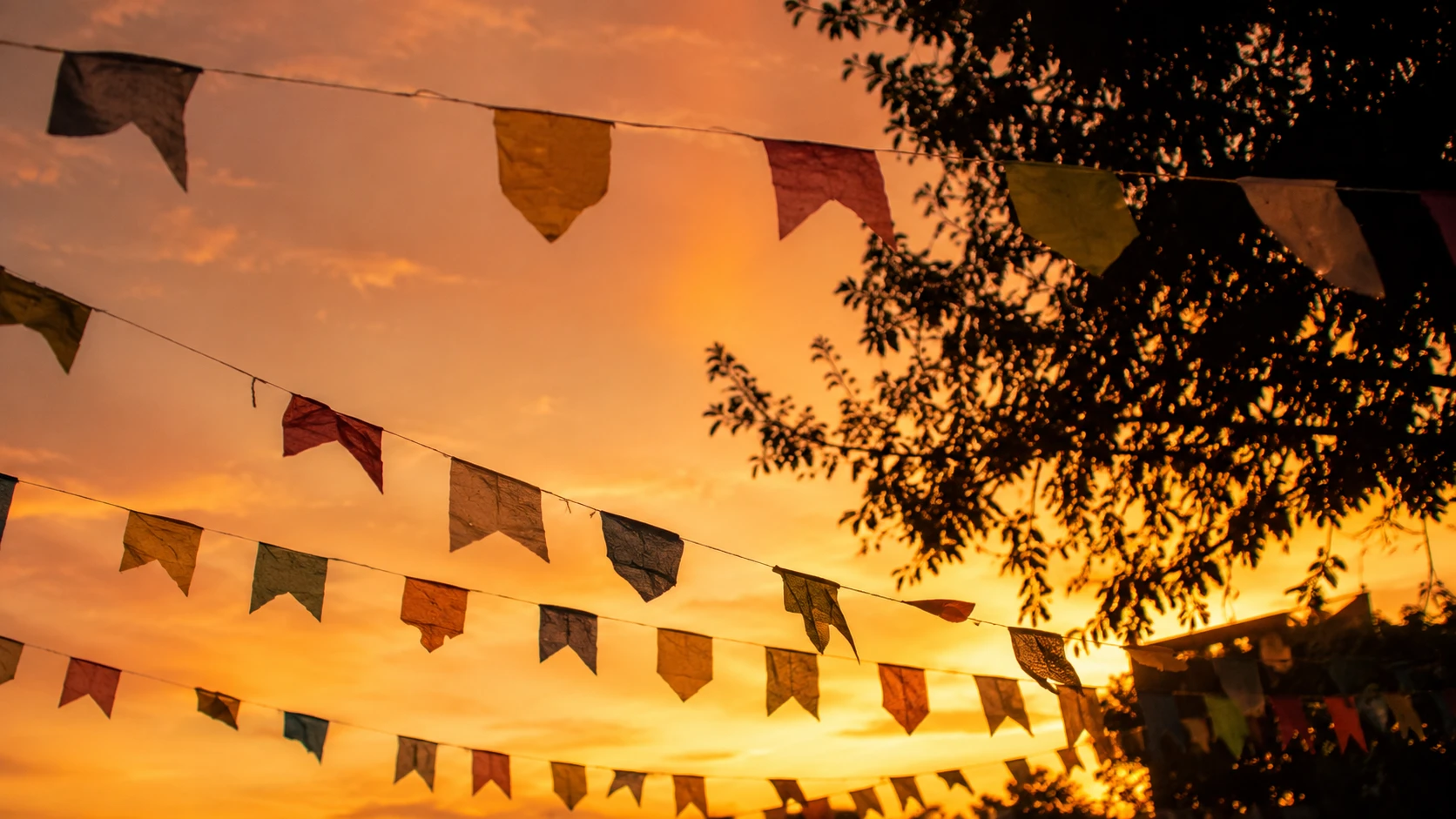 Bandeirinhas de papel penduradas em quintal ao entardecer — sonhar com festa
