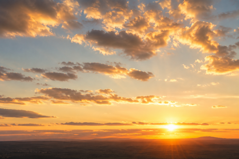 Céu ao entardecer com nuvens douradas e horizonte aberto, simbolizando transição e esperança à luz da Bíblia