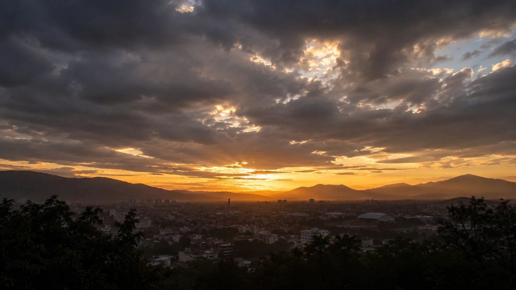 Cidade ao longe sob céu dramático com luz de amanhecer surgindo — sonhar com apocalipse